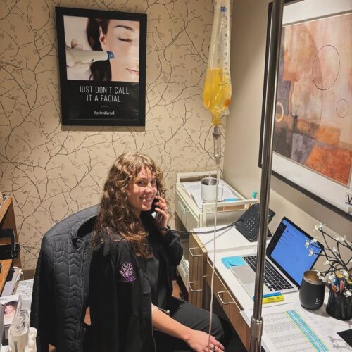 IV nutrition Therapy at Vitalogy Wellness and Med Spa Vitalogy Wellness staff member receiving IV nutrition therapy while working in a cozy treatment room.