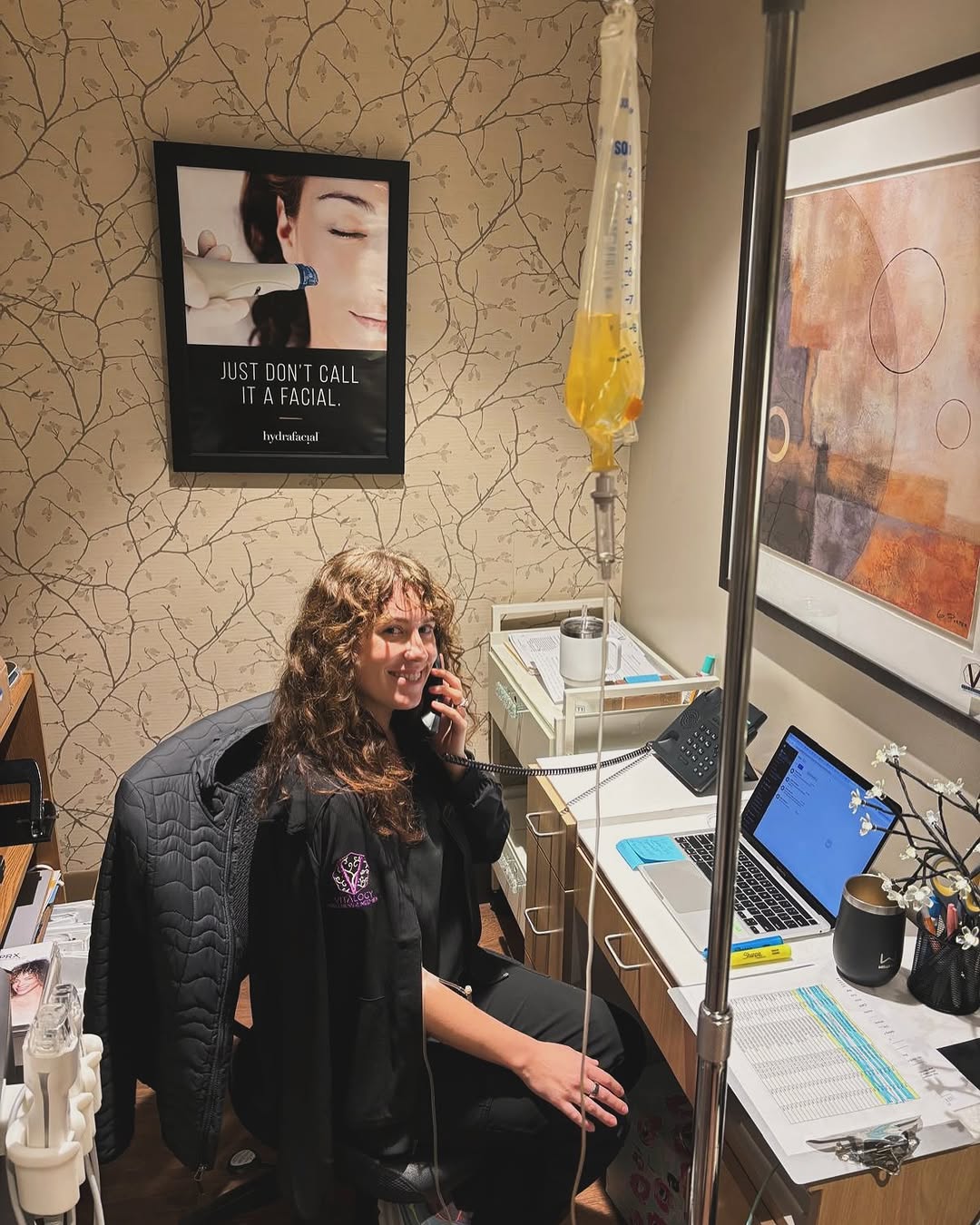 Vitalogy Wellness staff member receiving IV nutrition therapy while working in a cozy treatment room.